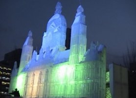Huge ice sculpture of a palace with lights inside the ice.
